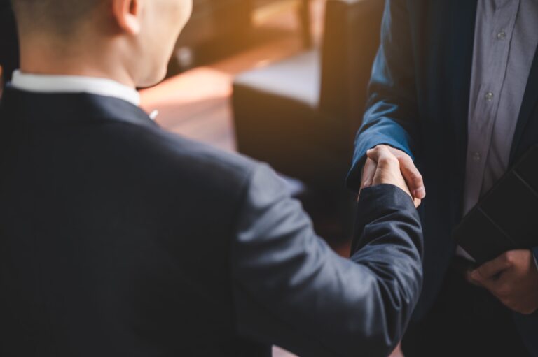 Two people shaking hands over a business agreement